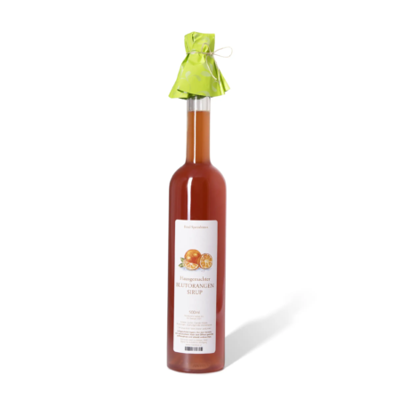 Flasche mit Blutorangensirup, leuchtend orangefarben, mit grünem Papierhut und dekorativem Band, weiße Etikette.